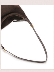 Close-up of a dark brown suede shoulder bag with a thin dark brown hobo bag 