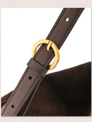 Close-up of a dark brown leather strap with a gold-tone circular ring buckle